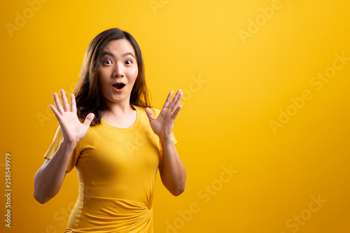 Happy woman thinking and standing isolated over yellow background