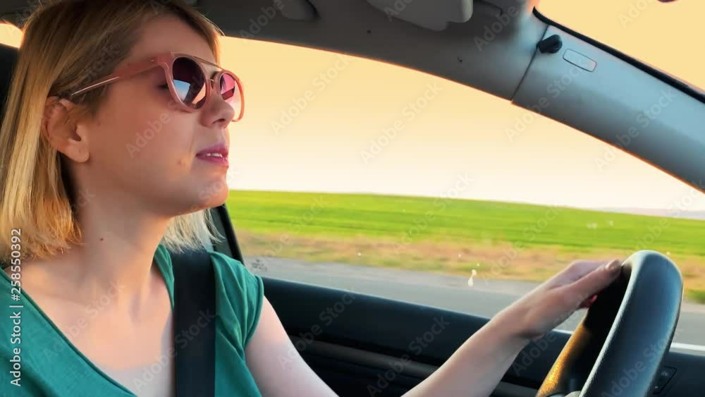 Girl driving car at sunset opening window slow motion 4k