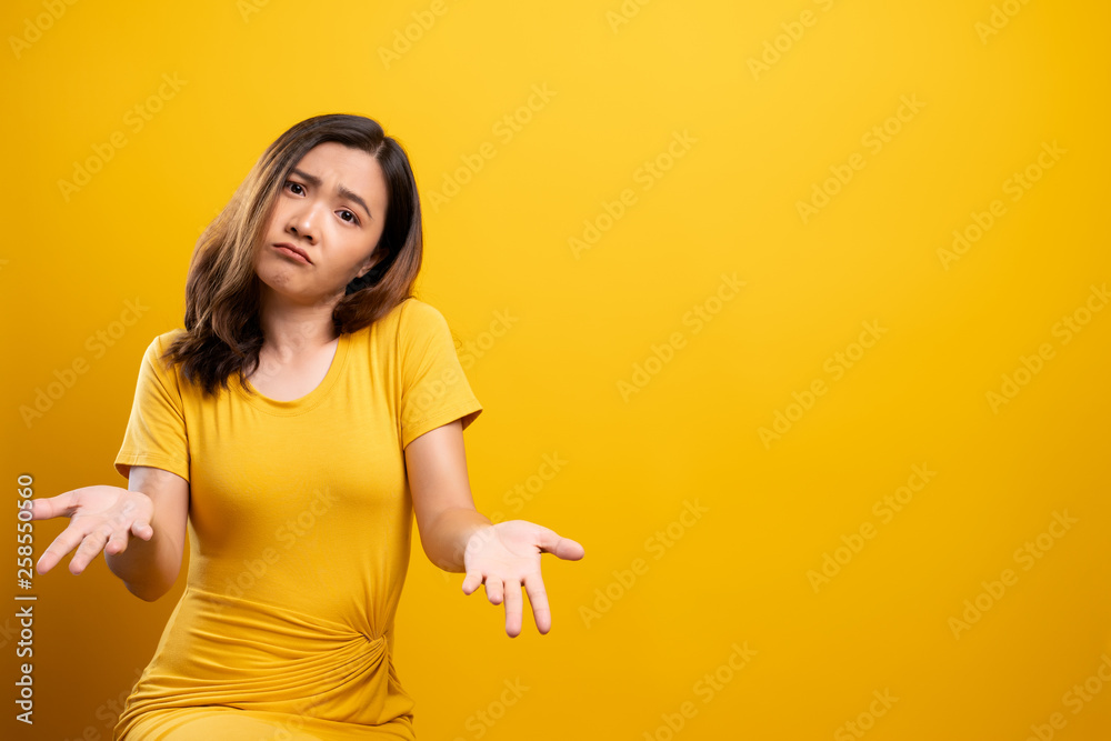 Woman feel confused isolated over yellow background Woman feel confused isolated over yellow background