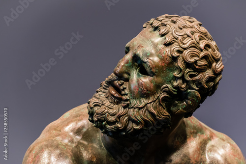 Detail of a face of an ancient roman bronze statue photo