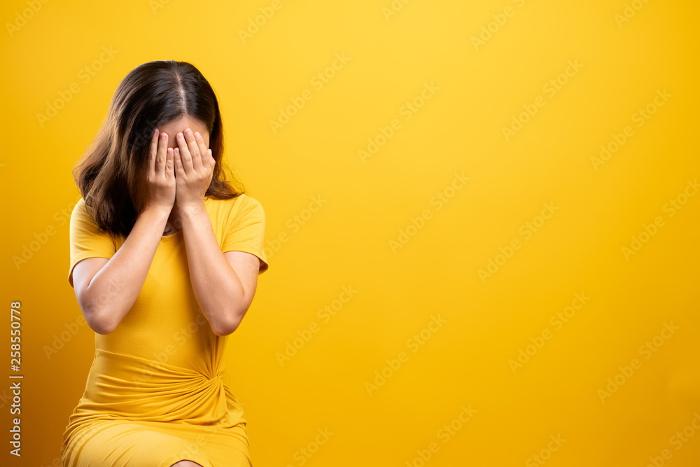 Sad woman isolated over yellow background Sad woman isolated over yellow background