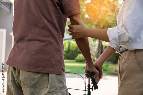Young woman hands are holding elderly man  hand with walker, care and encourage concept - Image