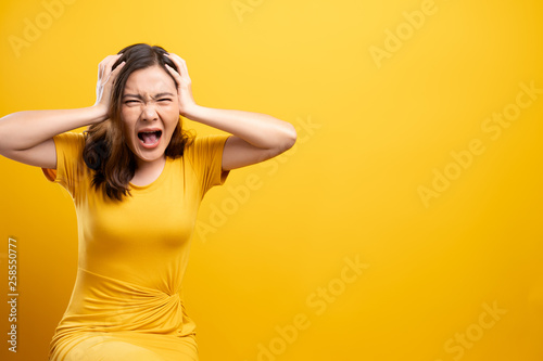 Angry woman screaming isolated over yellow background