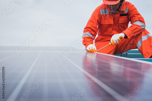 engineer in solar power plant working on installing solar panel ; operation of solar power plant by smart operator