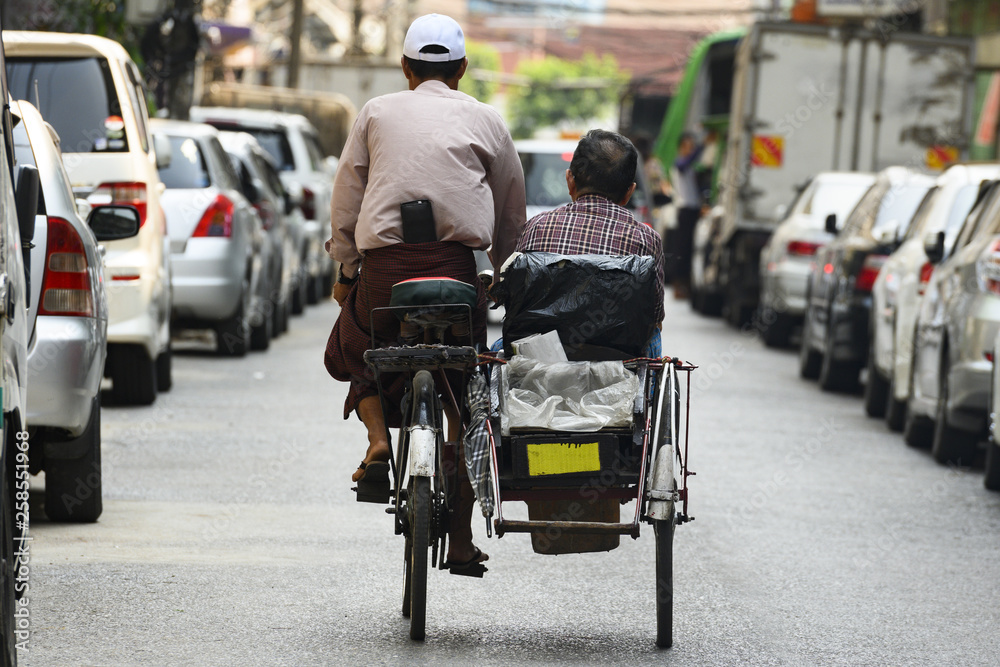 A unidentified Sai Kaa driver is carrying a passenger on his side car among the narrow streets of Yangon, Myanmar. The Sai Kaa rickshaw is a type of tricycle used in southeast Asia. A unidentified Sai Kaa driver is carrying a passenger on his side car among the narrow streets of Yangon, Myanmar. The Sai Kaa rickshaw is a type of tricycle used in southeast Asia.