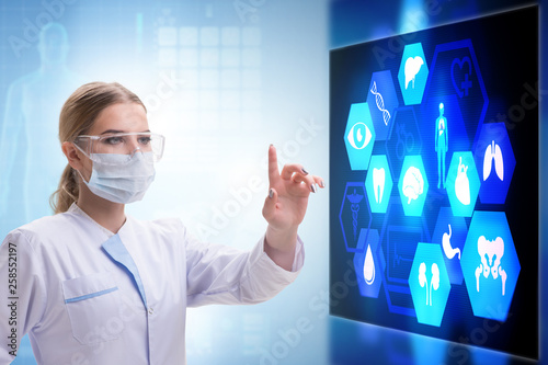 Woman doctor in telemedicine concept pressing touchscreen