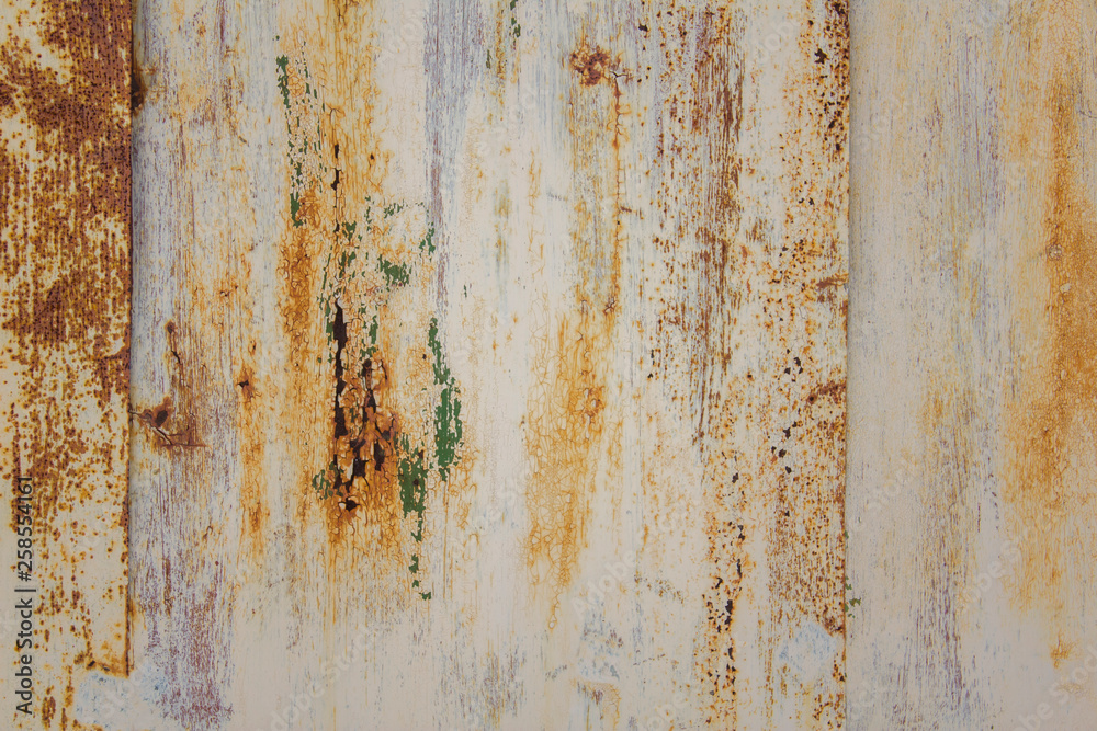 white peeling metal wall with scratches and stains of brown rust and green paint. rough surface texture white peeling metal wall with scratches and stains of brown rust and green paint. rough surface texture