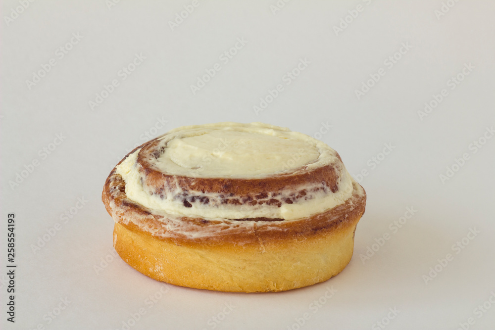 yellow brown round isolated cinnamon cinnabon cream cake closeup on white background