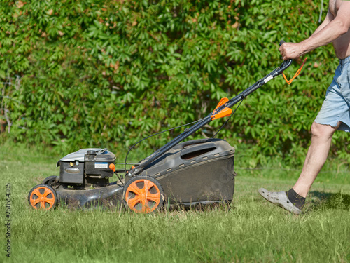 Country works on the personal plot using lawn mower.