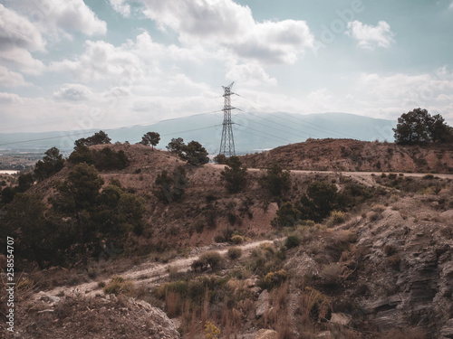 Dirt path to an electric tower on a hill 