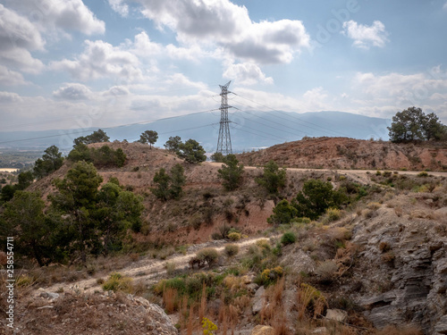 Dirt path to an electric tower on a hill 