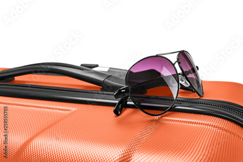 Closeup photo of glasses lying on top of orange valise