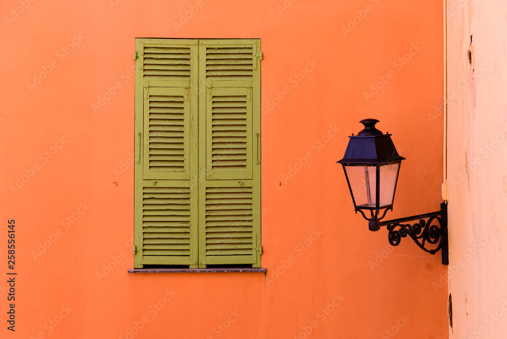 Architectural detail. The facade of the building with a window and a street lamp. Menton old town, France
