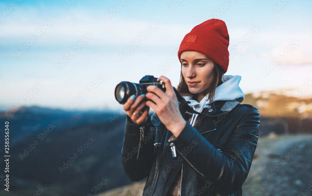 hipster tourist girl hold in hands take photography click on modern photo camera, photographer look on camera technology, journey landscape vacation concept, sun flare mountain - obrazy, fototapety, plakaty 