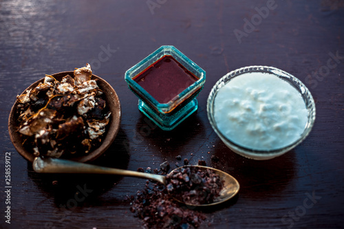 Ingredients of tamarind face pack on wooden surface which are Raw tamarind,raw curd or yogurt and rock salt.Made face pack in blue colored glass bowl.Used to clean bacteria from skin. photo