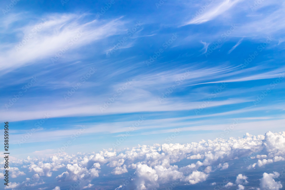 Blue sky with fluffy clouds; soft cirrus and stratocumulus white clouds in the sky. Beautiful view seen from the plane. Blue sky with fluffy clouds; soft cirrus and stratocumulus white clouds in the sky. Beautiful view seen from the plane.
