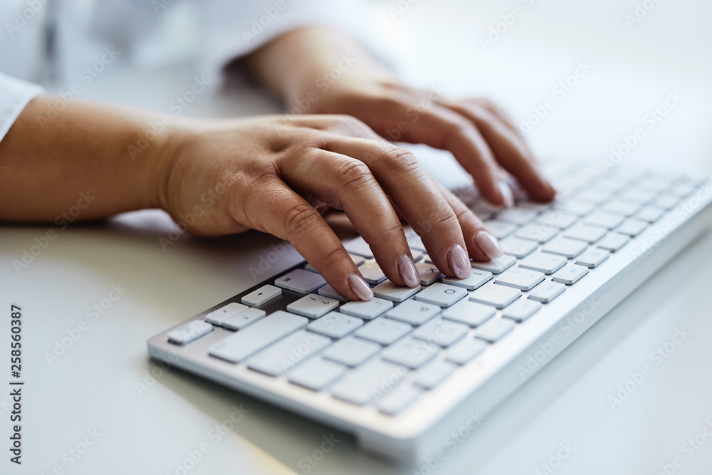 Female doctor typing on keyboard in the office, close up Female doctor typing on keyboard in the office, close up