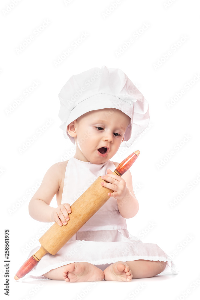 ten months old baby in a suit of the cook surprised and smiling in the kitchen. Small kid as a little cook or scullion make pizza in chef suit. Cooking child lifestyle concept. Toddler playing. ten months old baby in a suit of the cook surprised and smiling in the kitchen. Small kid as a little cook or scullion make pizza in chef suit. Cooking child lifestyle concept. Toddler playing.