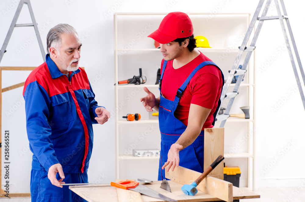 Two professional contractors laying flooring at home Two professional contractors laying flooring at home