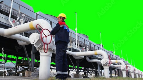 worker closes ball valve on cooling installations at gas compressor station, with alpha channel