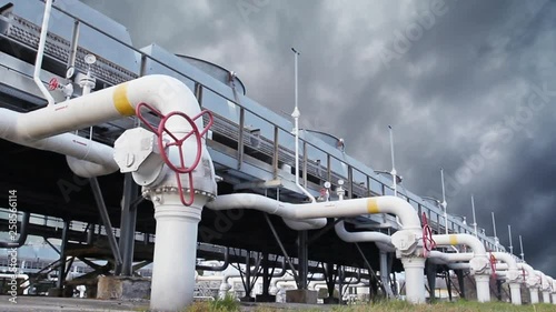 cooling installations at gas compressor station against background of thunderstorm sky, timelapse