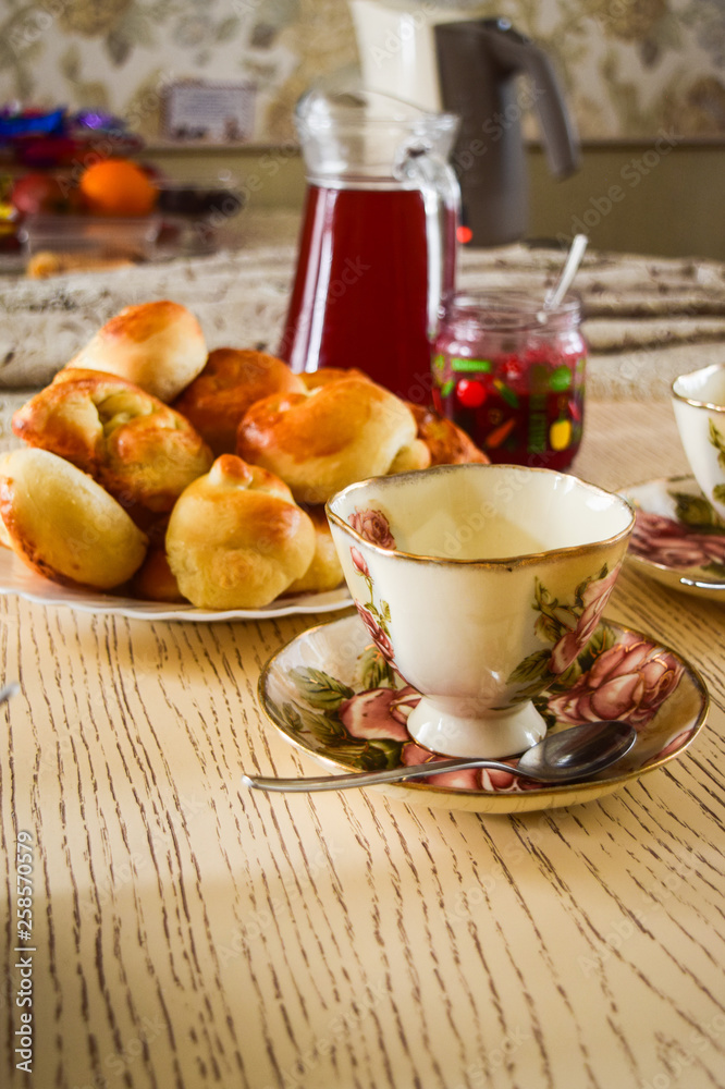 Tea with jam and cakes. Food and drinks on the dining table in different glass and ceramic dishes. Tea with jam and cakes. Food and drinks on the dining table in different glass and ceramic dishes.