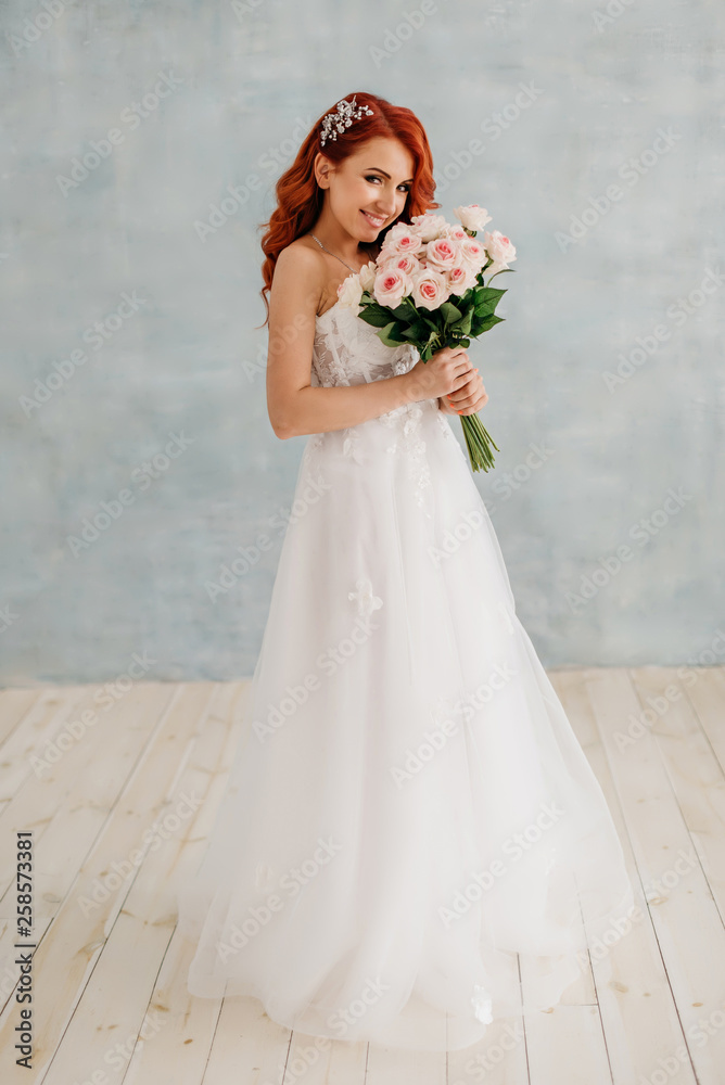 Happy red-haired bride stands with bouquet in her hands Happy red-haired bride stands with bouquet in her hands