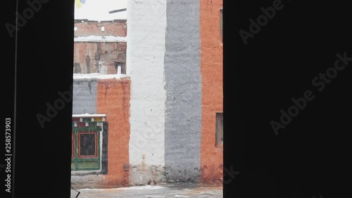 View of white horse walking past in the pouring rain on cobbled streets in Nepal Mustang Chhosar photo