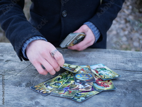 Wallpaper Mural Polonne / Ukraine - 5 March 2019: A man in a coat spreads a pack of tarot cards. Future reading concept Torontodigital.ca