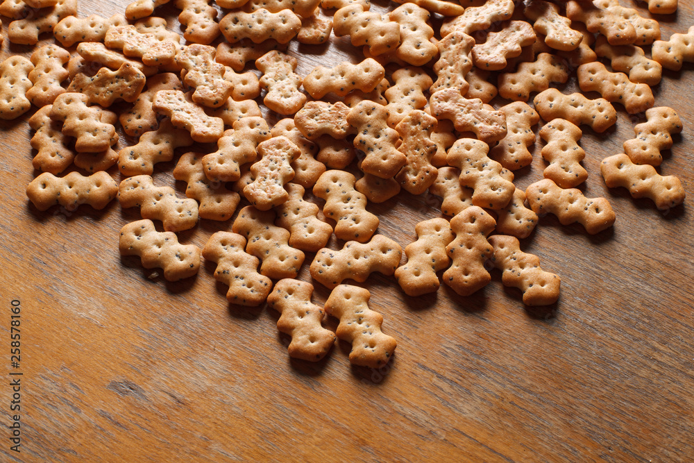 Fototapeta premium Composition of crackers with poppy seeds, spread out on a wooden background