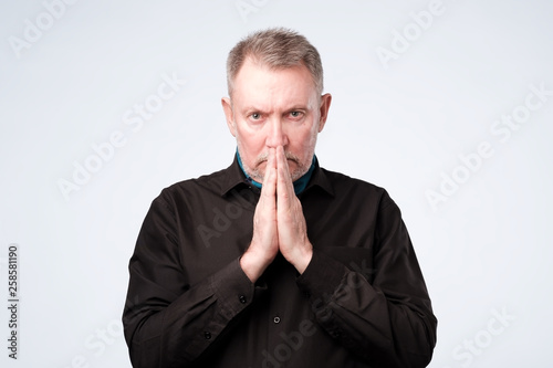 Old man put hands together in prayer or meditation