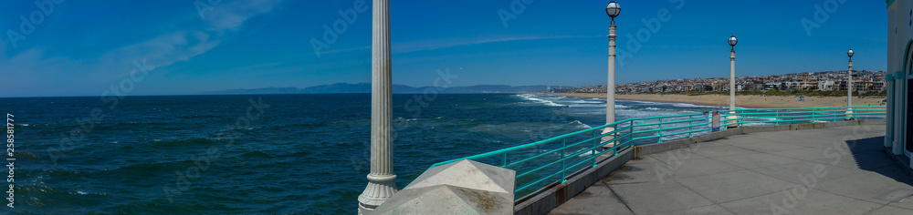 View of Southern California beach from pier on sunny day panorama