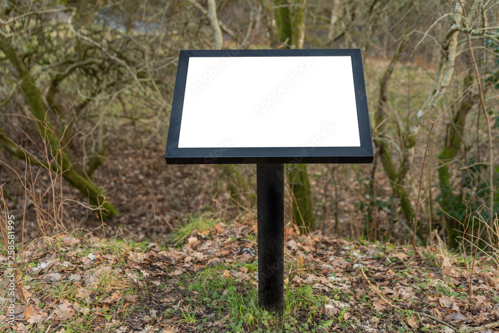 A metal blank notice board with copy space in a rural location.