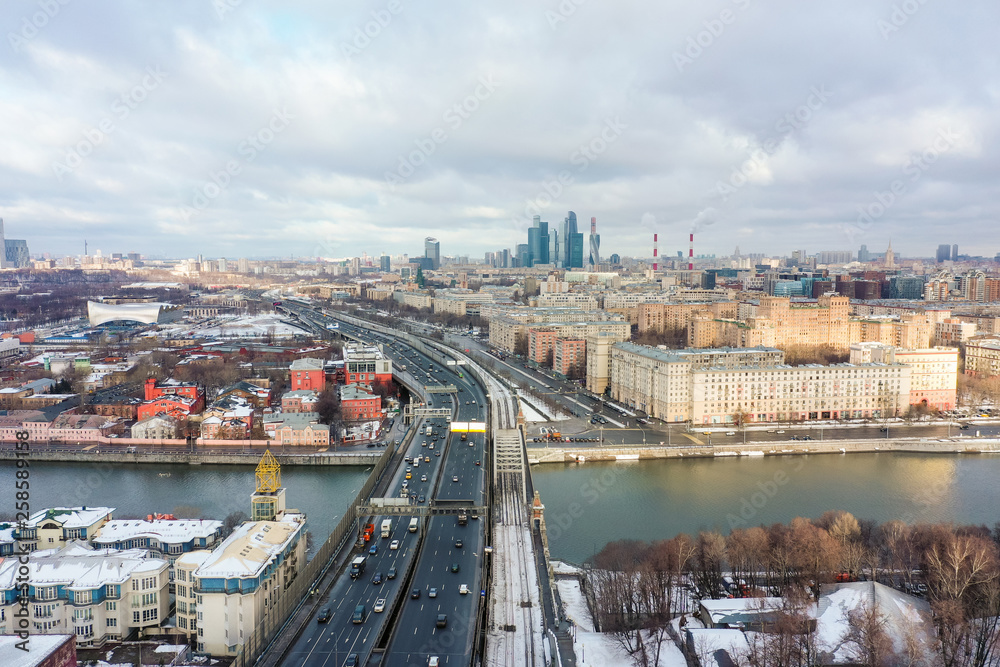 Skyscrapers and transport metropolis, cars traffic on multi-lane highways and road junction on sunny day in Moscow.