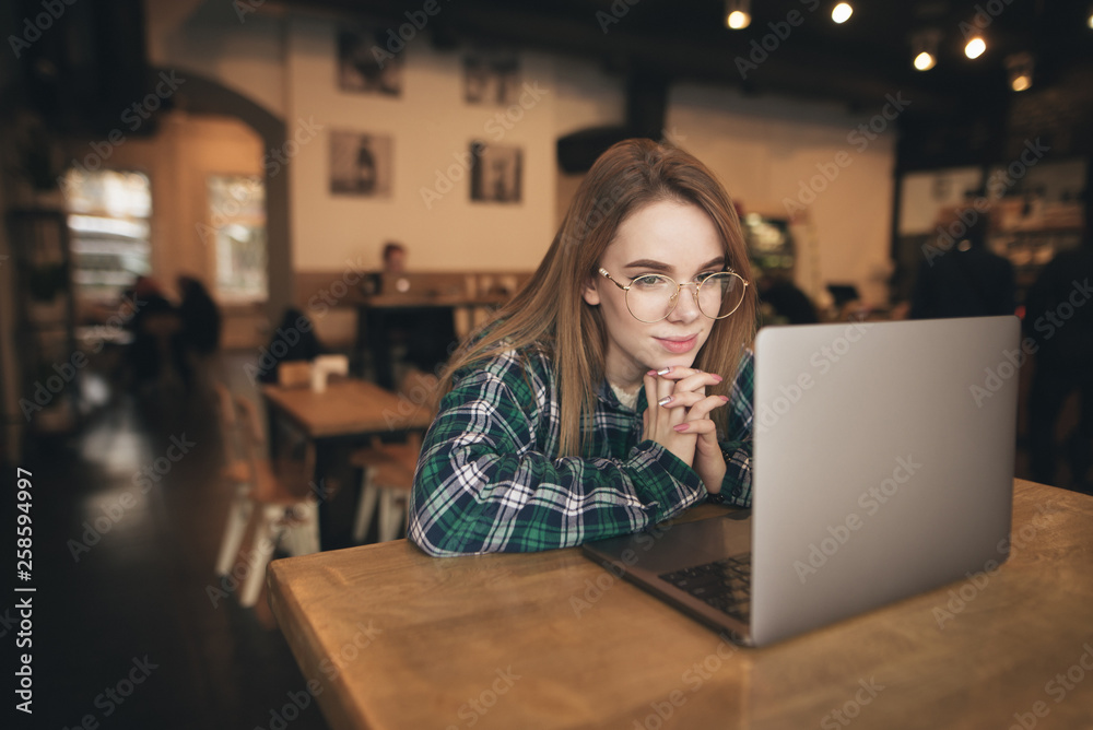 Beautiful brunette using notebook in cafe Beautiful brunette using notebook in cafe
