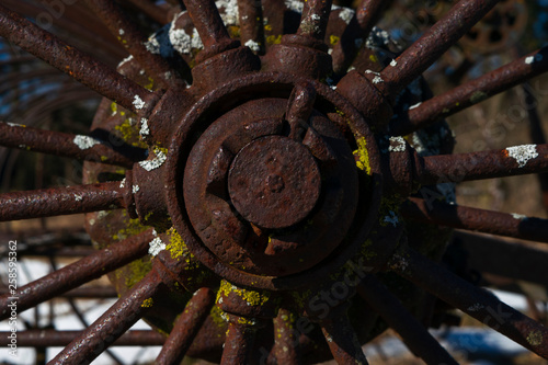 Close-up of rusty wheel with spokes on antique farm equipment