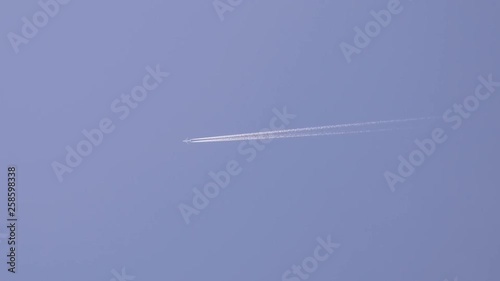 jet stream of airplane going in blue sky. photo