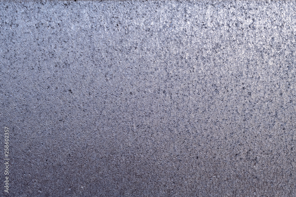 Detailed metallic texture of compressed melted and hammered and dented metal with gradient of shades