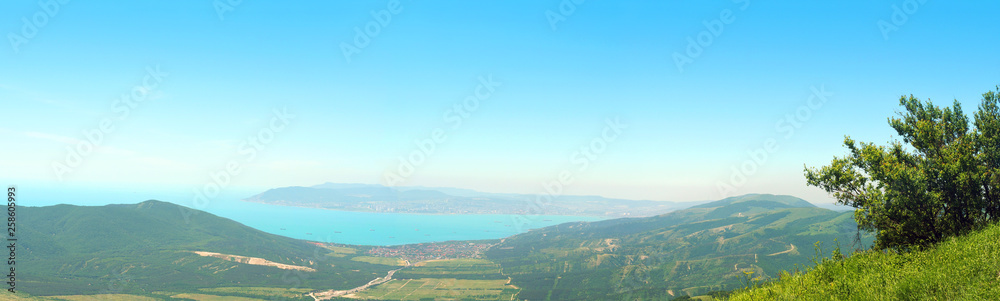 View from the summer green mountains Markotkh range to the Black Sea coast, bay, panoramic view. Rossia, Tsemesskaya Bay, Novorossiysk, Kabardinka