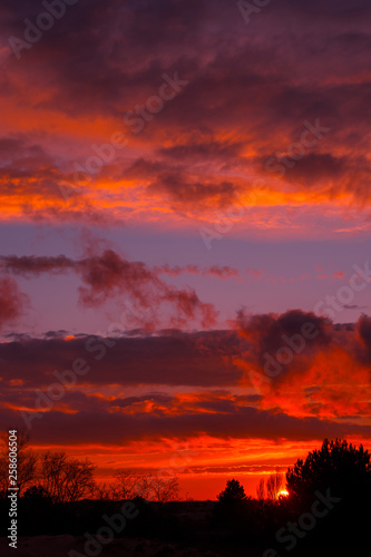 Fiery orange sunset  colorful and speckled  clouds. © Lumppini