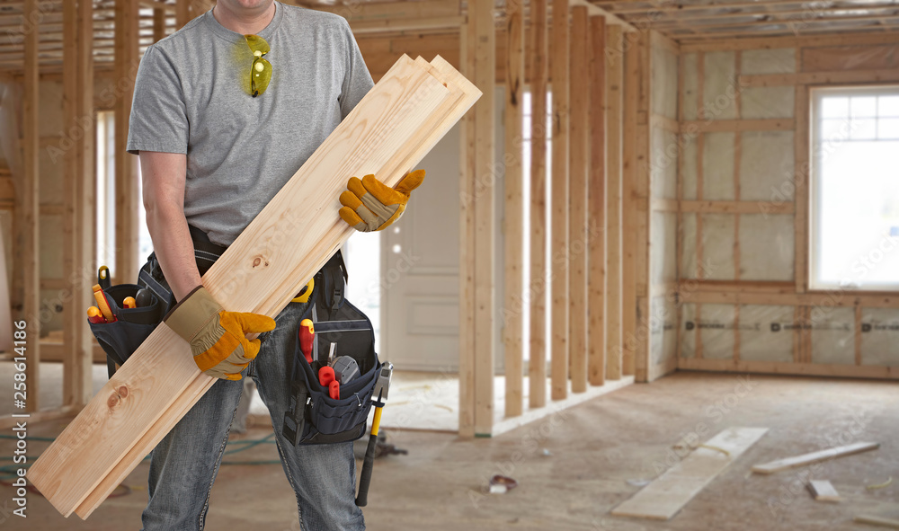 Builder handyman with wooden planks. - obrazy, fototapety, plakaty 