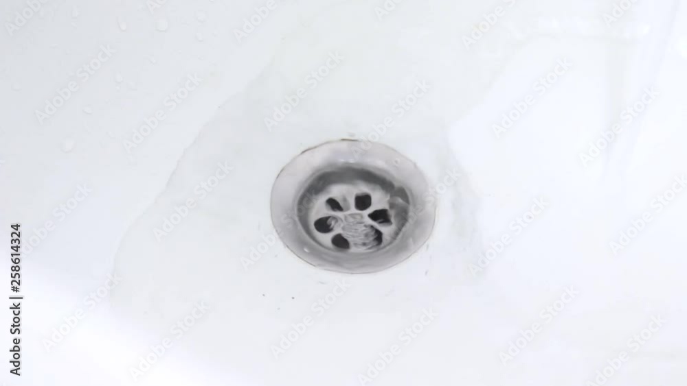 Bath drain hole close up, water is drawn into the bath and draining Bath drain hole close up, water is drawn into the bath and draining