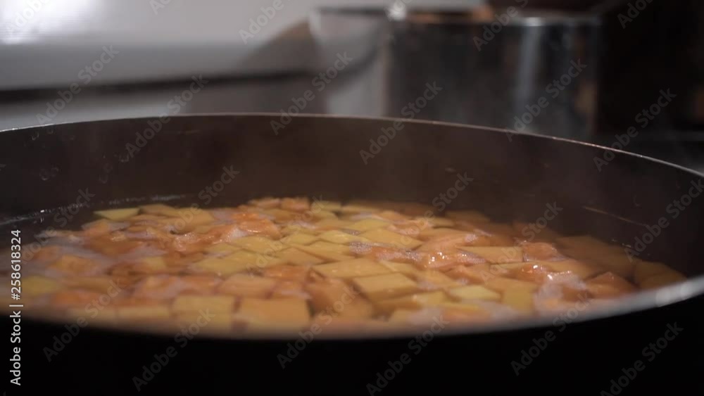 Butternut squash simmering in water with steam rising, Close Up Slider Left Butternut squash simmering in water with steam rising, Close Up Slider Left