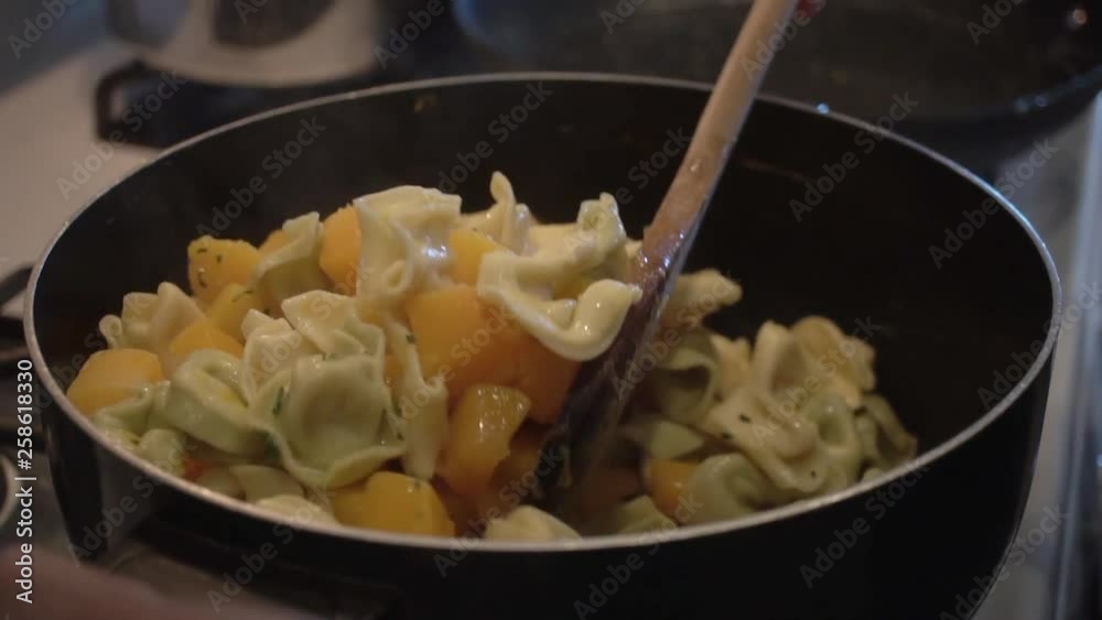Stirring tortellini and boiled butternut squash in pot, Slow Motion Close Up Stirring tortellini and boiled butternut squash in pot, Slow Motion Close Up