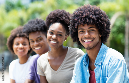 Handsome african american man with group of young adults in line