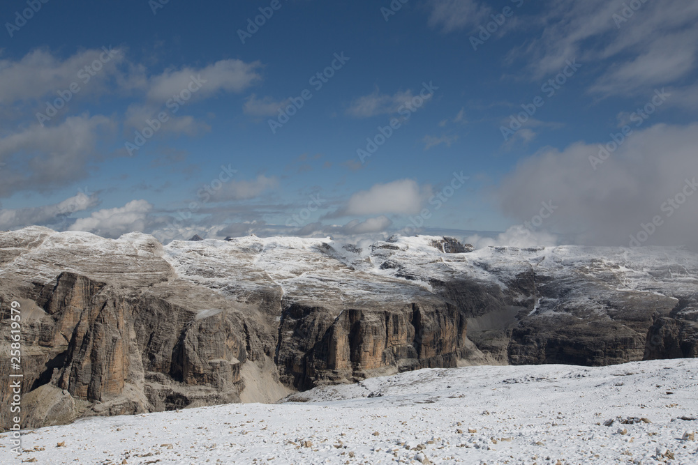 Beautiful wide Landscape of the Dolomites, view from Sass Pordoi in spring where the mountains are still covered in Snow