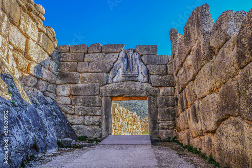 Bright Greek sunlight shines of rock wall of ancient Mycenae on the road up to the famous Lions Gate into the hill fortress where the armies of Troy originated photo