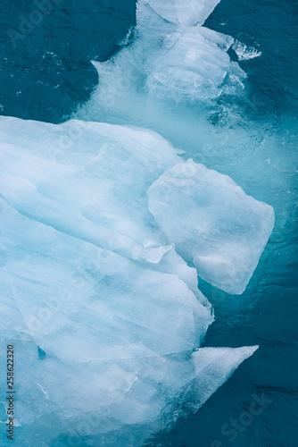 Beautiful ocean aquamarines and blues with close up of a small floating iceberg as a nature background