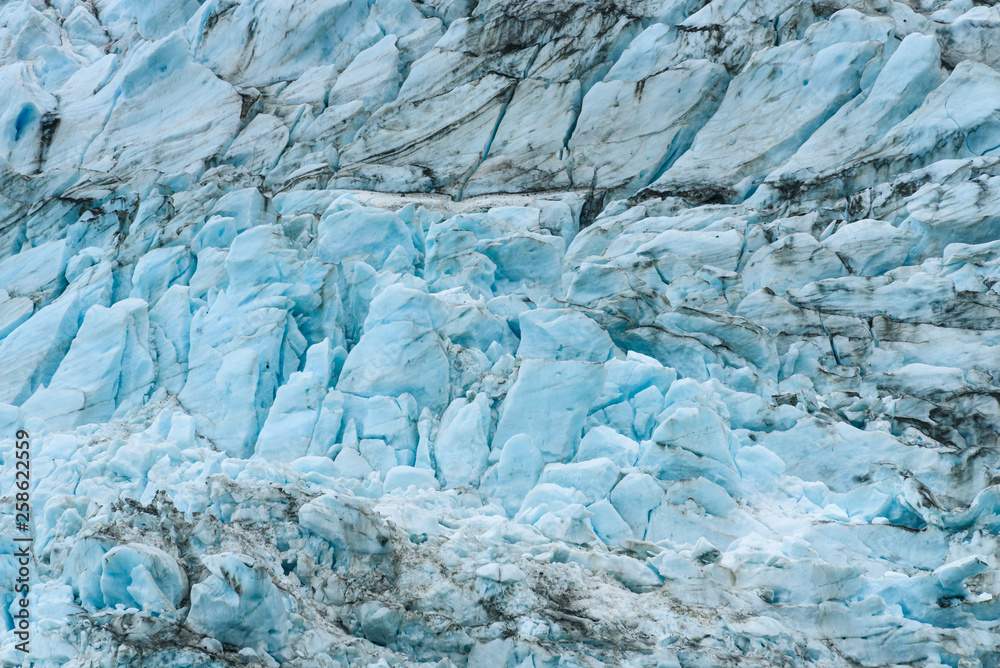 Glacial blues and dirt browns in fractured ice patterns on glacier in Drygalski Fjord, South Georgia, as a nature background