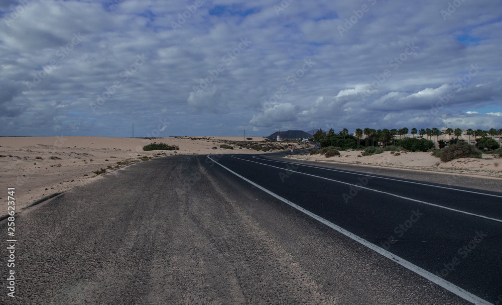 long strip of asphalt in the sand dunes of Fuerteventura, Canary Islands